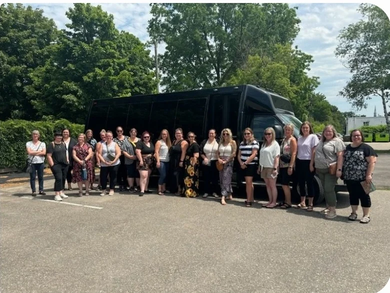 Guests standing beside an ALR shuttle bus before a group event pickup.
